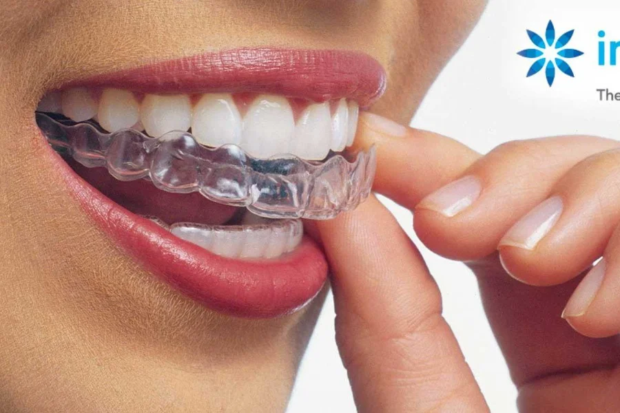 Paciente colocándose un alineador transparente Invisalign